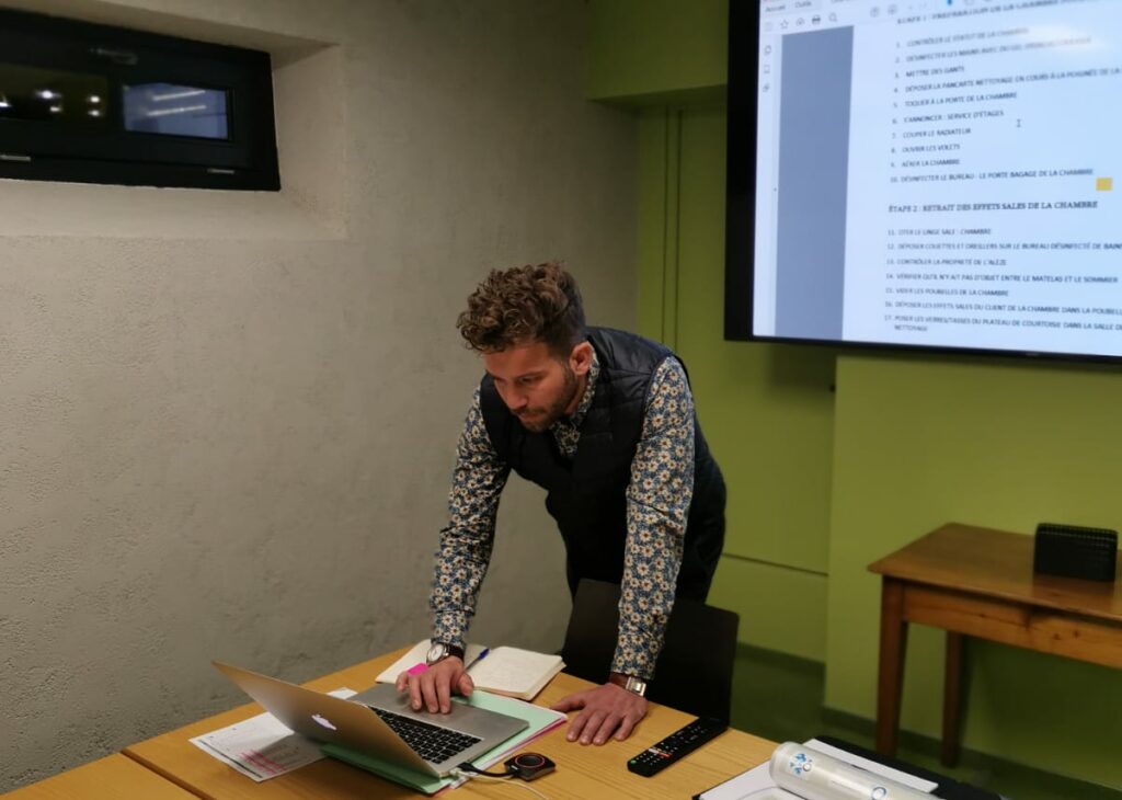 un coach debout derrière son ordinateur 