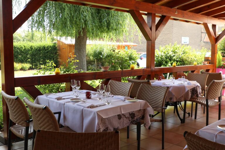 salle extérieur du restaurant lion d'or sous une véranda en bois